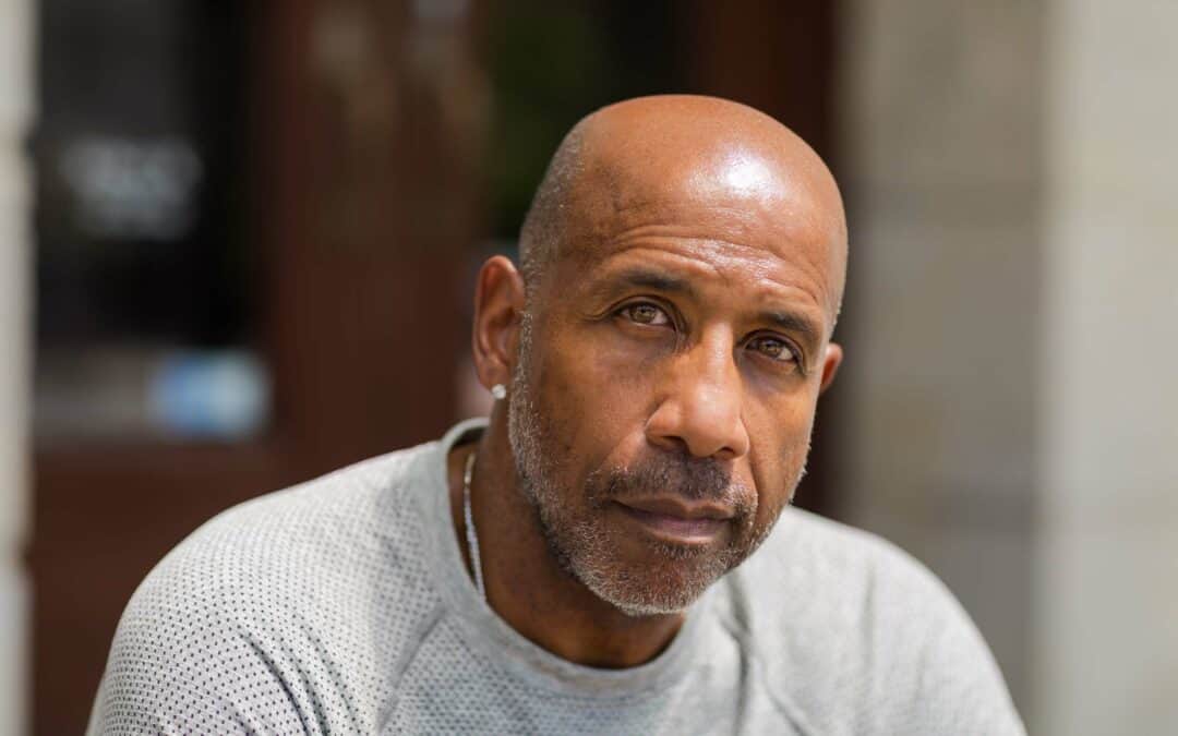 Middle aged African American male sitting and staring at the camera